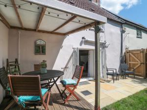 a patio with a table and chairs on a deck at Old Farm Cottage in Warminster