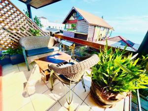 a balcony with chairs and a table and a house at Green​ house​ Samui in Bophut