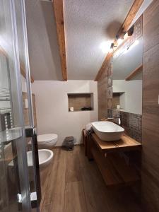 łazienka z umywalką, wanną i toaletą w obiekcie Agritur Broch w mieście Fiera di Primiero