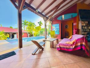 a bedroom with a bed and a table and a pool at Sunset Surf Camp in Saint-François