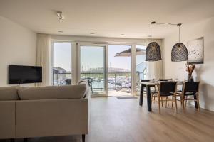 a living room with a couch and a table with chairs at Apartment Havenzicht 8a Kortgene in Kortgene