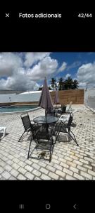 a group of chairs and a table with an umbrella at Condominio Reserva do Delta 1 in Parnaíba