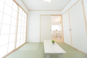 a white table in a room with windows at Miraie Suzuka Shimomida in Suzuka