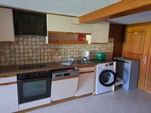 a kitchen with a sink and a washing machine at Familienfreundliches Bregenzerwälderhaus in Au im Bregenzerwald