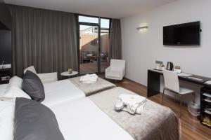 a hotel room with a couch and a television at Catalonia Catedral in Barcelona