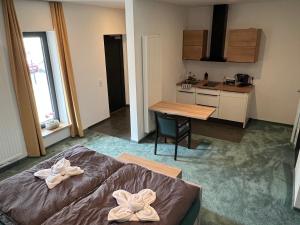 a room with a bed and a table and a kitchen at PAULINEN Residenz Komfortabel wohnen - Flexibel ankommen in Detmold