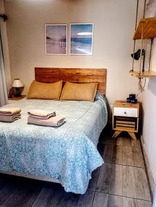 a bedroom with a bed with two towels on it at La Maruja de Chapa in Chapadmalal