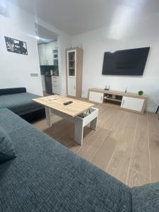 a living room with a coffee table and a flat screen tv at Can Paquito Fuerteventura in Corralejo +18 photos