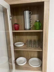 a wooden cabinet with plates and cups in it at Can Paquito Fuerteventura in Corralejo