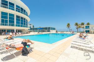 Un grupo de personas tumbadas en sillas de jardín junto a una piscina. en Girasole Rentals Suites, en Miami Beach 12 fotos más