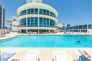 a swimming pool in front of a building at Girasole Rentals Suites in Miami Beach