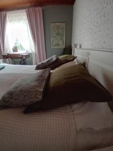 1 Schlafzimmer mit 2 Betten mit Kissen und einem Fenster in der Unterkunft Bobackan pihatorpan kammarit in Alvettula