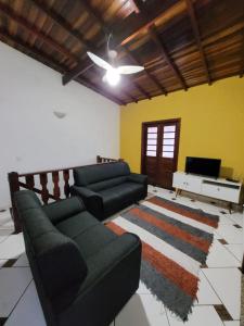 Una sala de estar con dos sofás y un televisor. en MDQ Hostel Paraty, en Paraty