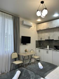 Habitación con cocina y mesa con sillas. en Shine Hill შაინ ჰილი, en Tsinsvla