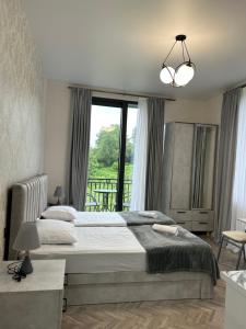 Un dormitorio con una cama y una ventana grande. en Shine Hill შაინ ჰილი, en Tsinsvla