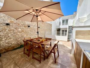 a table and chairs with an umbrella on a patio at Cor de Mar • Pátio • 2 Quartos • Centro Histórico in Peniche