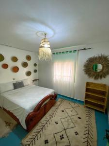 a bedroom with a bed and a chandelier at Sunny Soul Taghazout in Taghazout