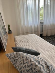 リーヴァ・デル・ガルダにあるDueOlivi - Appartamento Blueのベッド2台と窓のある寝室