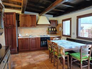 a kitchen with wooden cabinets and a table and chairs at La chiave dei tre Abruzzi in Popoli