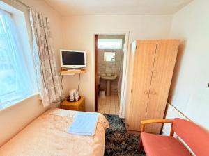 a small bedroom with a bed and a television at Hylands Hotel Single Room with Shared Bathroom & Free Parking in Nottingham