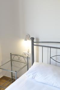 a bedroom with a bed with a lamp and a glass table at Babis Apartment Agios Nikitas in Agios Nikitas