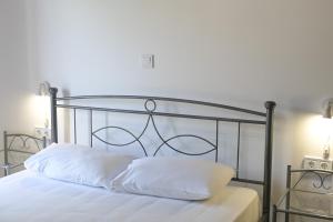 a bed with white sheets and a metal head board at Babis Apartment Agios Nikitas in Agios Nikitas