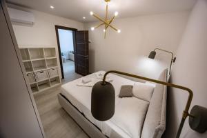 a small bedroom with a bed and a lamp at GuestHost - Sliema Breeze & Patio Comfort in Sliema