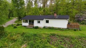 乌拉勒德Henrys utanför Ullared的院子里有黑色屋顶的白色房子