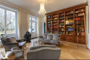 a living room with chairs and a large book shelf at Château De Saint Mayeul in Joze