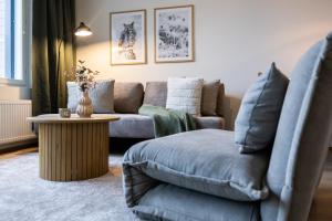 a living room with a couch and a table at Cozy Suite with Sauna and Balcony - Heart of Lapland in Rovaniemi