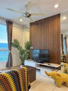 a living room with a tv and a ceiling fan at Georgetown Mansion One Apartment by Jere Penang Gleneagles Gurney in George Town