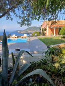 a house with a swimming pool next to the ocean at VILLA ANDRONIKI in Fiskardo