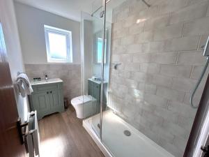 a bathroom with a shower and a toilet and a sink at Anchorage - Quaint and Cosy Two-Bedroom House in Poole +23 photos