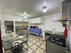 a kitchen with a table and a stove top oven at Casa 02 Mansão Bardo 2 qts Piscina Petrópolis RJ - Venha para Baurnfest in Petrópolis