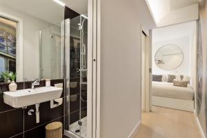 a bathroom with a sink and a shower and a bed at Ola Living Santa Anna in Barcelona +72 photos