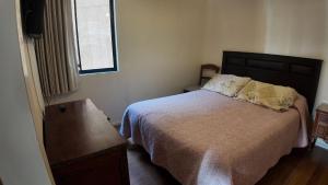 a bedroom with a bed and a table and a window at Departamento Familiar en Concón in Concón +38 photos