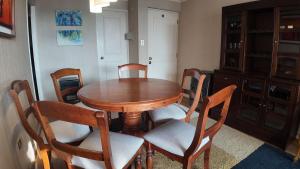 a dining room with a wooden table and chairs at Departamento Familiar en Concón in Concón