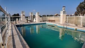 a pool of blue water in front of a building at Departamento Familiar en Concón in Concón