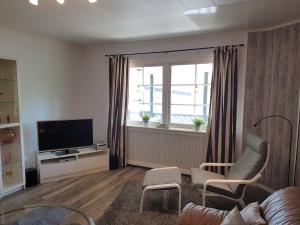 a living room with a couch and a tv and a window at Villa Majringen in Vidsel