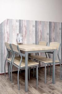 tavolo e sedie in una stanza con parete di Click Apartamenty Portowa a Kołobrzeg