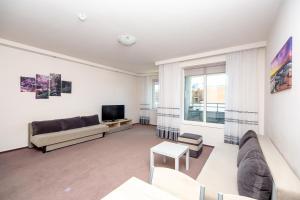 un soggiorno con un divano e una TV di Click Apartamenty Portowa a Kołobrzeg