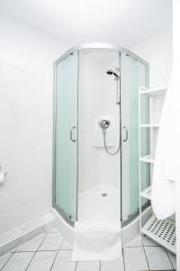 una doccia con una porta in vetro in un bagno di Click Apartamenty Portowa a Kołobrzeg