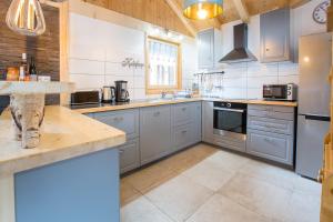 a large kitchen with blue cabinets and appliances at Simply Morzine - Apartment du Centre in Les Gets +23 photos