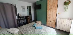 a bedroom with a bed with two blue towels on it at Le petit nid champêtre in Montesquieu-Lauragais