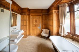a bathroom with two sinks and a tub and a chair at The Wood Norton in Evesham +145 photos