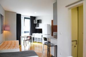 a room with a bed and a desk with a table at São Pedro City Flat in Vila Real