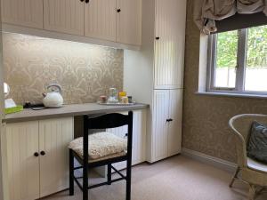 a kitchen with a counter and a chair under a table at Orchard Paddocks in Guildford +31 photos