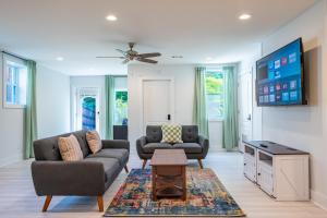 a living room with two couches and a tv at Modern 2BR Retreat Near Emory & Downtown ATL in Atlanta