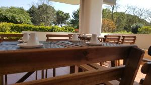 a wooden table with napkins on top of a patio at Phalanthos B&B in Leporano