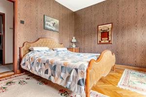 ベオグラードにある100 m2 Apartment in the Diplomatic Area of Belgrade, Serbiaの木製の壁の部屋にあるベッドのある寝室